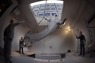 The first component of the linac-MRI -- the system's ring gantry on which linac parts are mounted -- is lowered by crane through a modular roof into one of UMC Utrecht's radiotherapy treatment rooms.