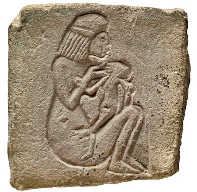 Limestone stela decorated with a representation of a woman suckling a child. 18th Dynasty.
