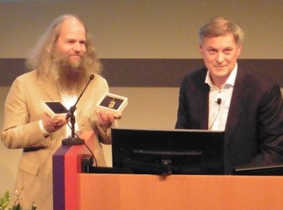 Wim van Harten presents Marcel van Herk with a copy of an Antoni van Leeuwenhoek microscope.