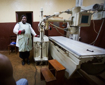 Above: Conditions in many African hospitals remain poor. In this photo, a permanent radiology unit broke down, necessitating use of a mobile unit. The technician is wearing a substandard apron, degraded with use and poor storage conditions. Below: A technician stands at the controls of an x-ray machine behind a wall missing its lead glass screen. He wears a lead apron, but his head is unprotected. 'Staff working in this kind of environment are the real unsung heroes,' Dr. Klaus Schönenberger said. Images courtesy of Sylvain Liechti.