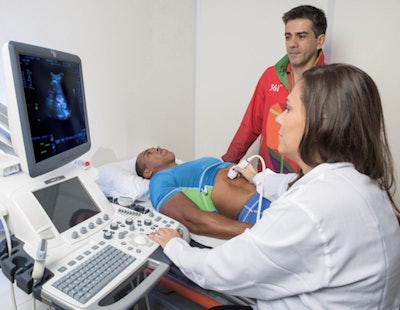 Priscilla Souza, a clinical application specialist from GE Healthcare, tests the ultrasound equipment on Edson Freitas Da Silva.