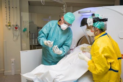 Radiologist Dr. Jan Vanrusselt takes a biopsy of a deceased COVID-19 patient. Courtesy of hbvl.be.