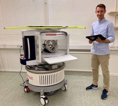 Emil Ljungberg holds the tablet that controls the 64 mT Hyperfine scanner.