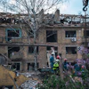 Firefighters in Kyiv inspect a damaged building after an attack, illustrating the destruction wrought by the war.