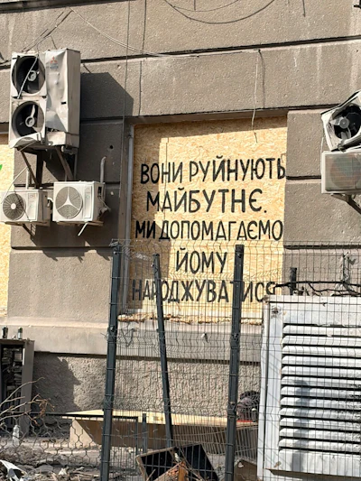 A message painted on the facade reads, “They destroy the future. We help bring it to life.”
