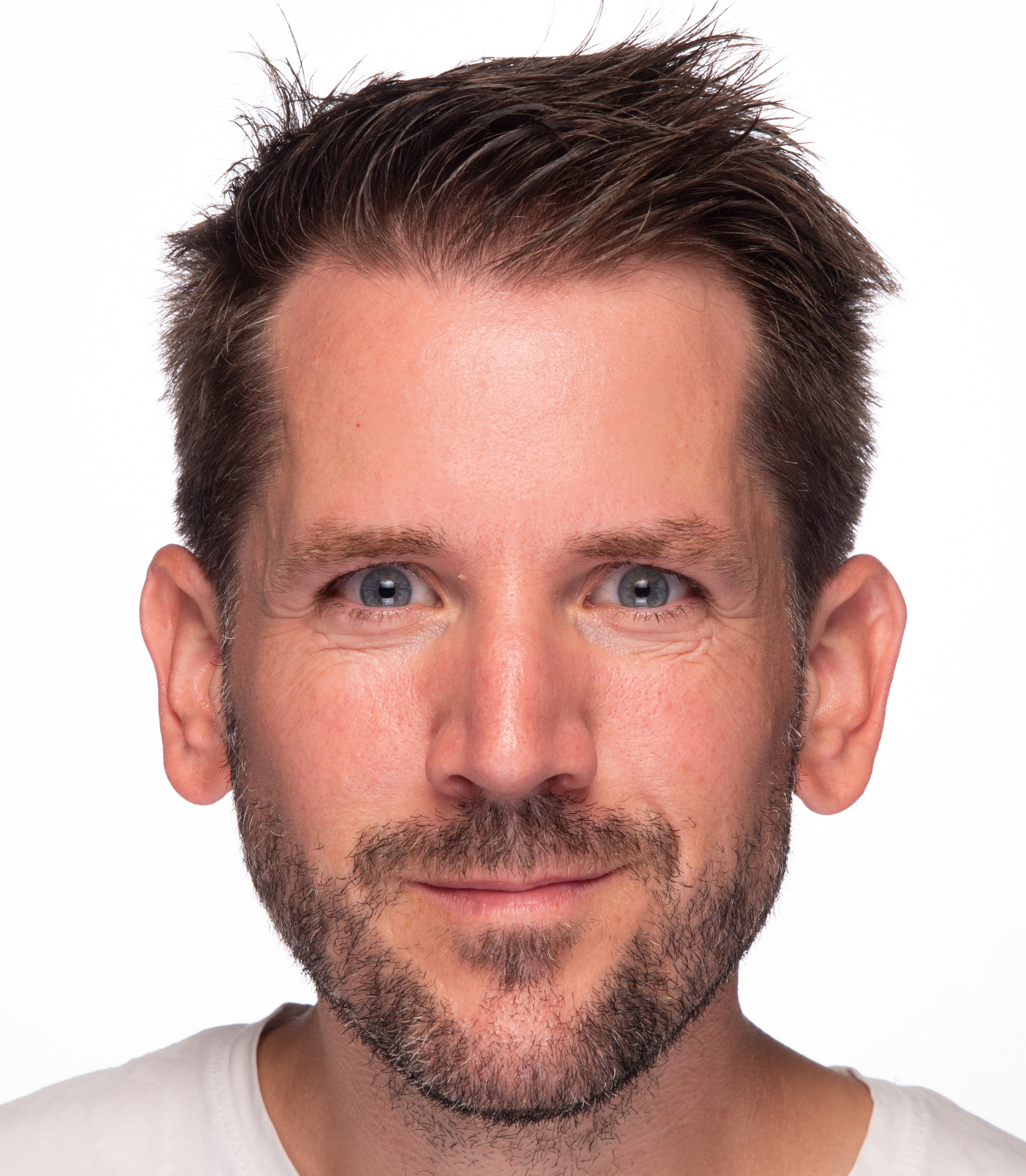 Professional headshot of a man with dark hair and facial hair against a white background