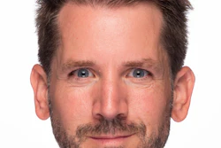 Professional headshot of a man with dark hair and facial hair against a white background