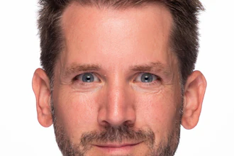 Professional headshot of a man with dark hair and facial hair against a white background