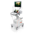 Portable ultrasound machine with monitor displaying forest imagery, control panel, and mobile cart base