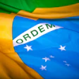 Brazilian flag waving with green, yellow, and blue colors and white band with 'ORDEM' text