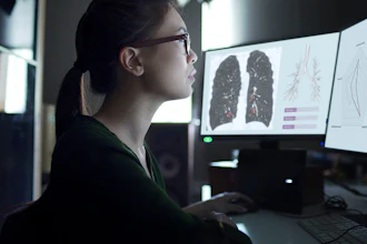 Medical professional reviewing lung CT scan images on multiple monitors in diagnostic workstation