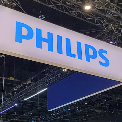 Philips brand signage displayed on a large blue and white banner at an indoor trade show or exhibition venue