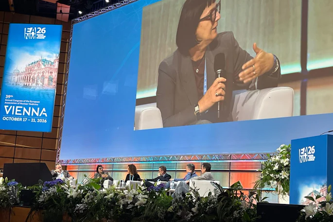 Panel discussion at ISTAT26 conference in Vienna with speaker presenting on stage while seated panelists listen