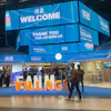 EIA26 Vienna conference venue with blue overhead displays welcoming attendees and orange 'VILLAGE' signage at the entrance