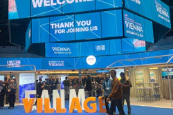 EIA26 Vienna conference venue with blue overhead displays welcoming attendees and orange 'VILLAGE' signage at the entrance